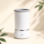 White automatic pet paw cleaner in a warm ivory studio setting.
